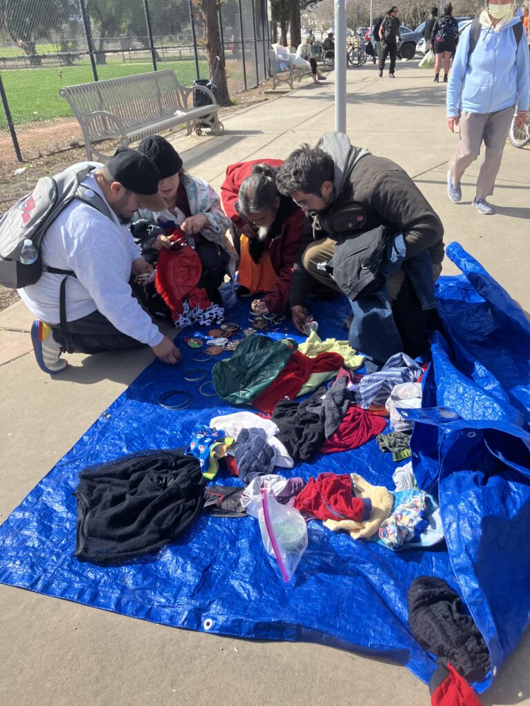 People in the community gathering around clothes that were donated.